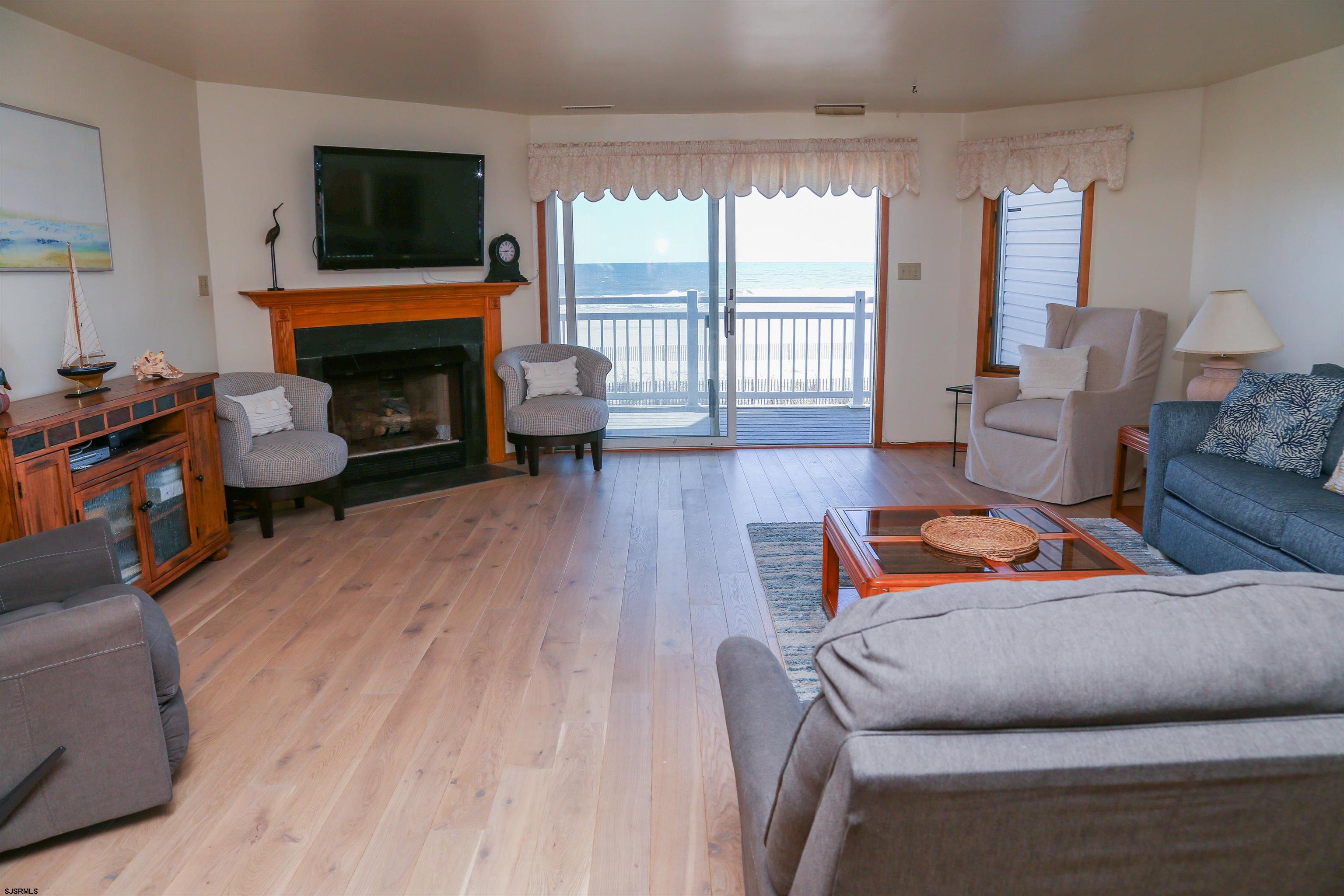 512 East Brigantine Avenue, Unit 512 Brigantine, NJ 08203 - Photo 19 of 46 a living room with furniture a flat screen tv and a fireplace