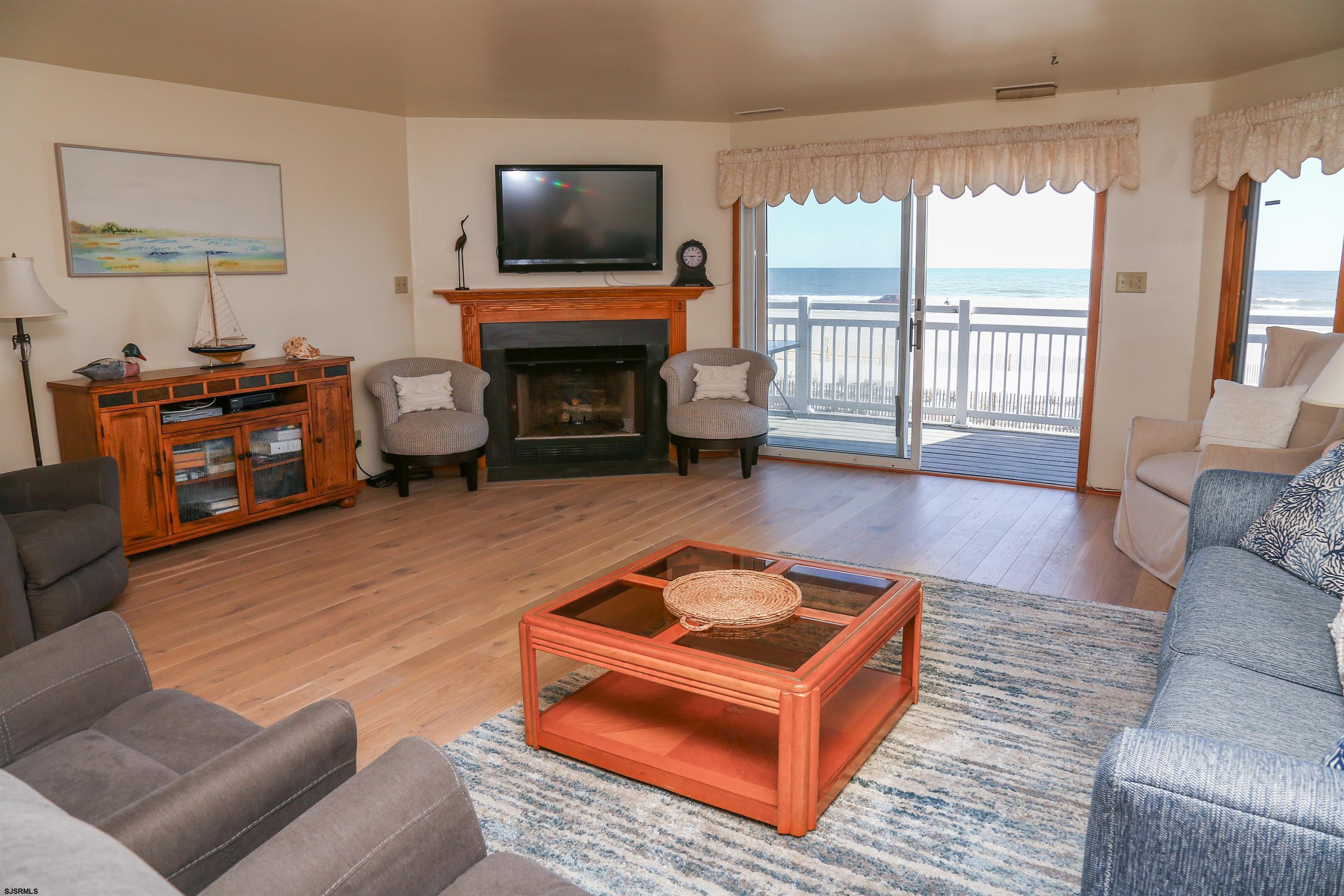 512 East Brigantine Avenue, Unit 512 Brigantine, NJ 08203 - Photo 20 of 46 a living room with furniture a flat screen tv and a fireplace