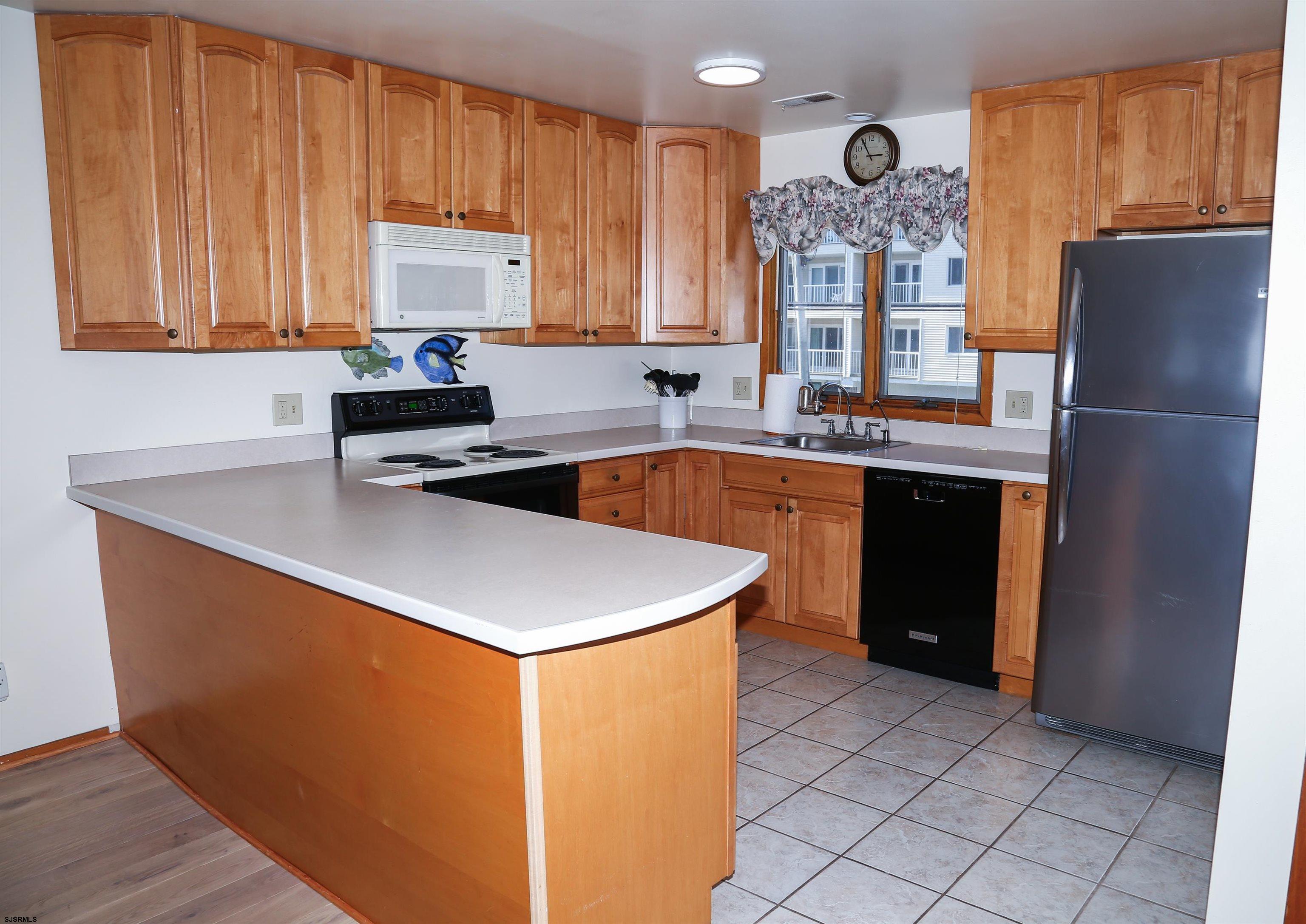 512 East Brigantine Avenue, Unit 512 Brigantine, NJ 08203 - Photo 25 of 46 a kitchen with stainless steel appliances granite countertop a sink stove and refrigerator