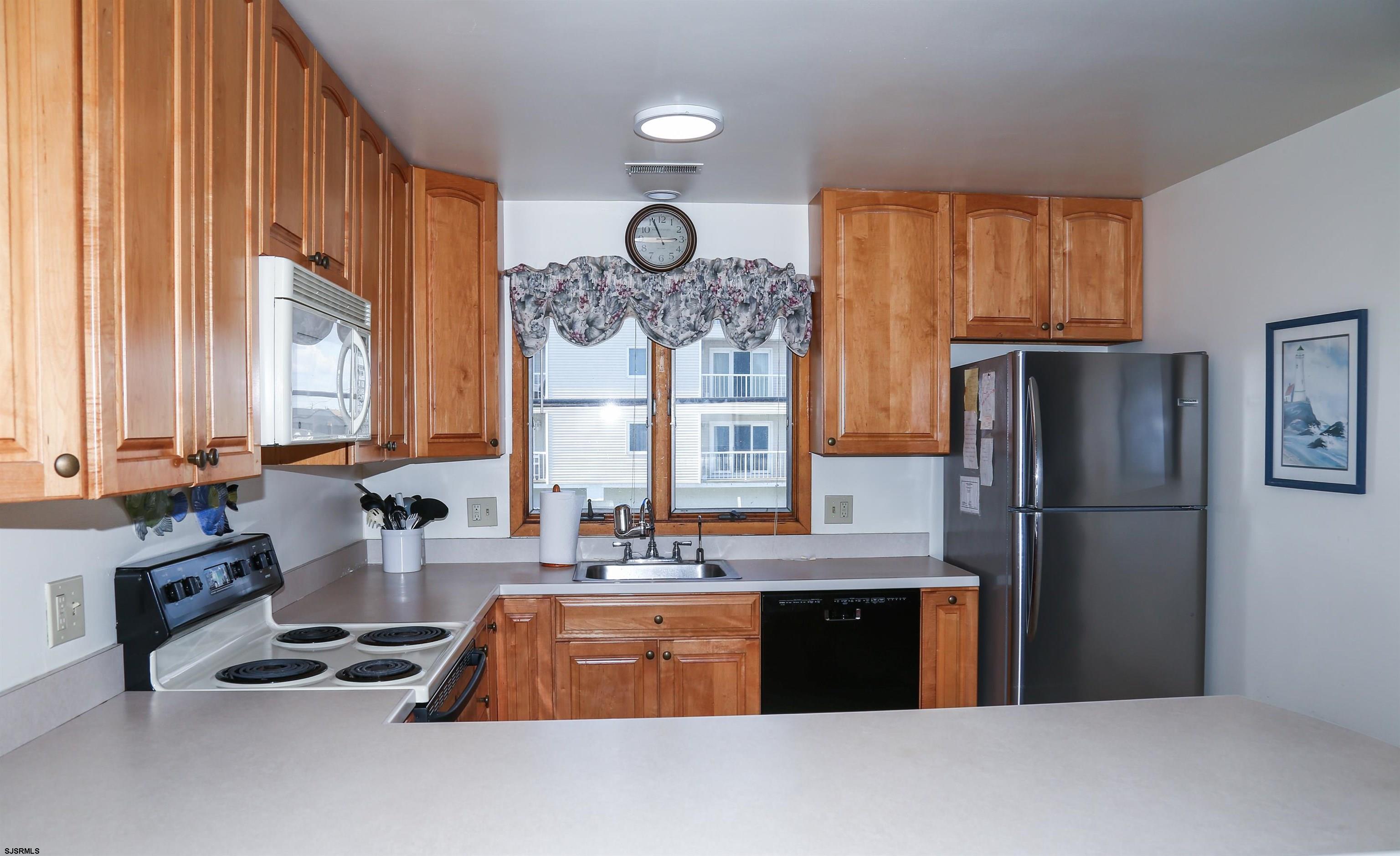 512 East Brigantine Avenue, Unit 512 Brigantine, NJ 08203 - Photo 26 of 46 a kitchen with granite countertop a refrigerator stove top oven and sink