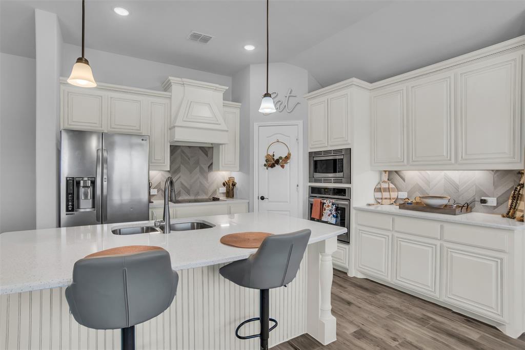 1566 Harrison Circle Waxahachie, TX 75165 - Photo 23 of 38 a kitchen with stainless steel appliances kitchen island granite countertop a sink a microwave a refrigerator and chairs
