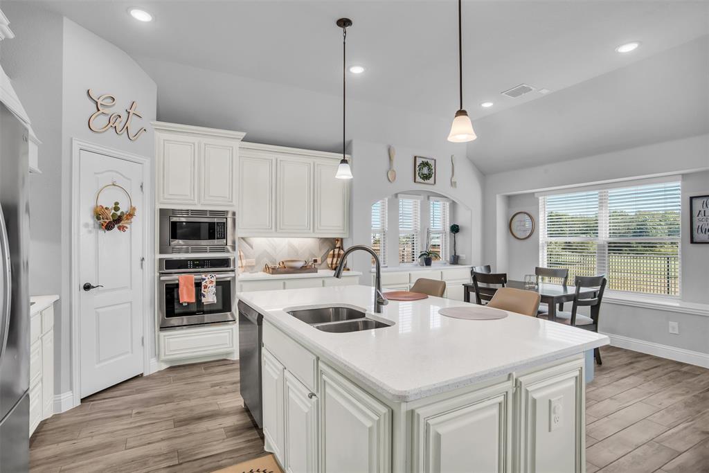1566 Harrison Circle Waxahachie, TX 75165 - Photo 24 of 38 a kitchen with stainless steel appliances granite countertop a sink a stove a refrigerator cabinets and living room view