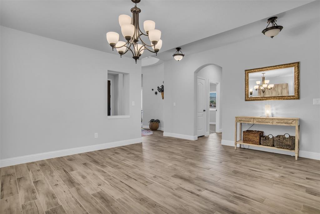 1566 Harrison Circle Waxahachie, TX 75165 - Photo 9 of 38 a view of an empty room with a fireplace and wooden floor