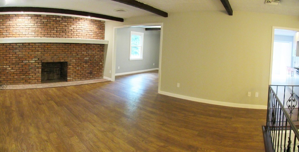 93 Wheelock Road Sutton, MA 01590 - Photo 3 of 30 a view of an empty room with wooden floor and a fireplace
