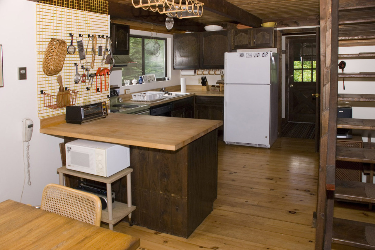 77 Stebbins Road Otis, MA 01253 - Photo 11 of 17 a kitchen with a refrigerator a stove and a dining table with wooden floor