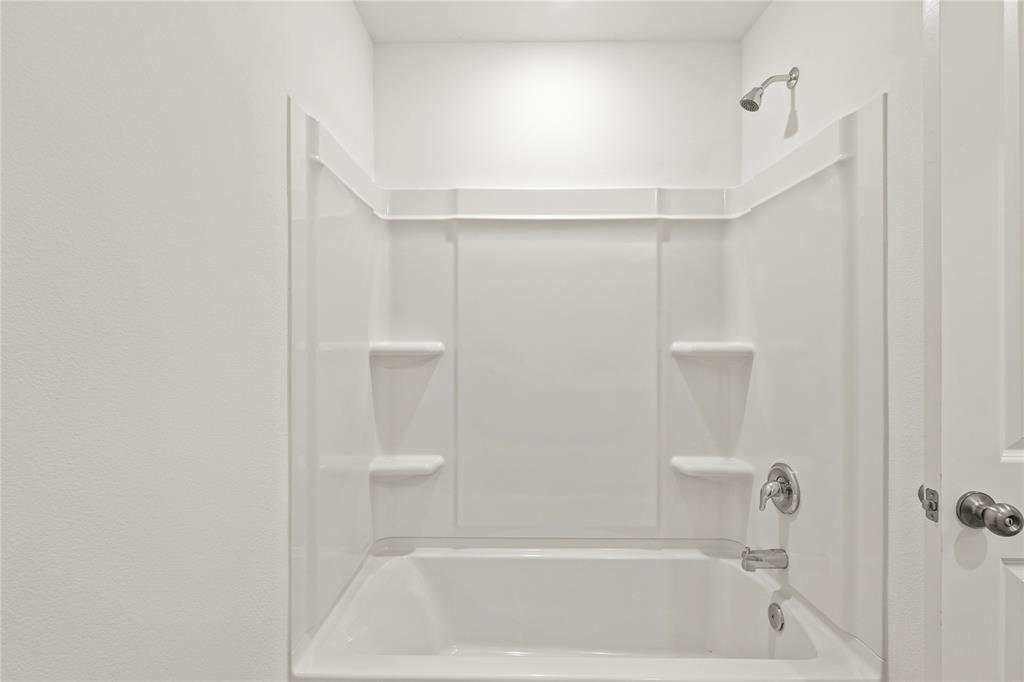 1138 Barbary Flds Street Forney, TX 75126 - Photo 22 of 25 Tub and shower combination featuring integrated shelving and a polished chrome fixture set