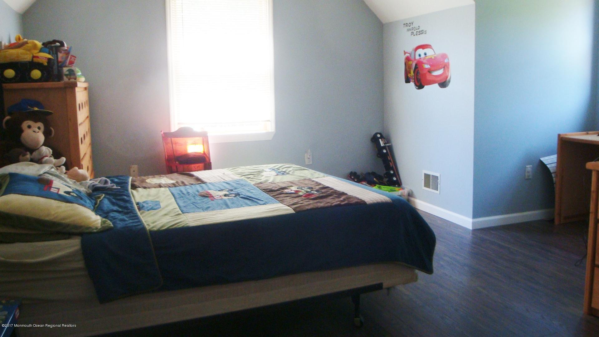 2323 Maple Road Forked River, NJ 08731 - Photo 13 of 23 a bedroom with a bed and wooden floor