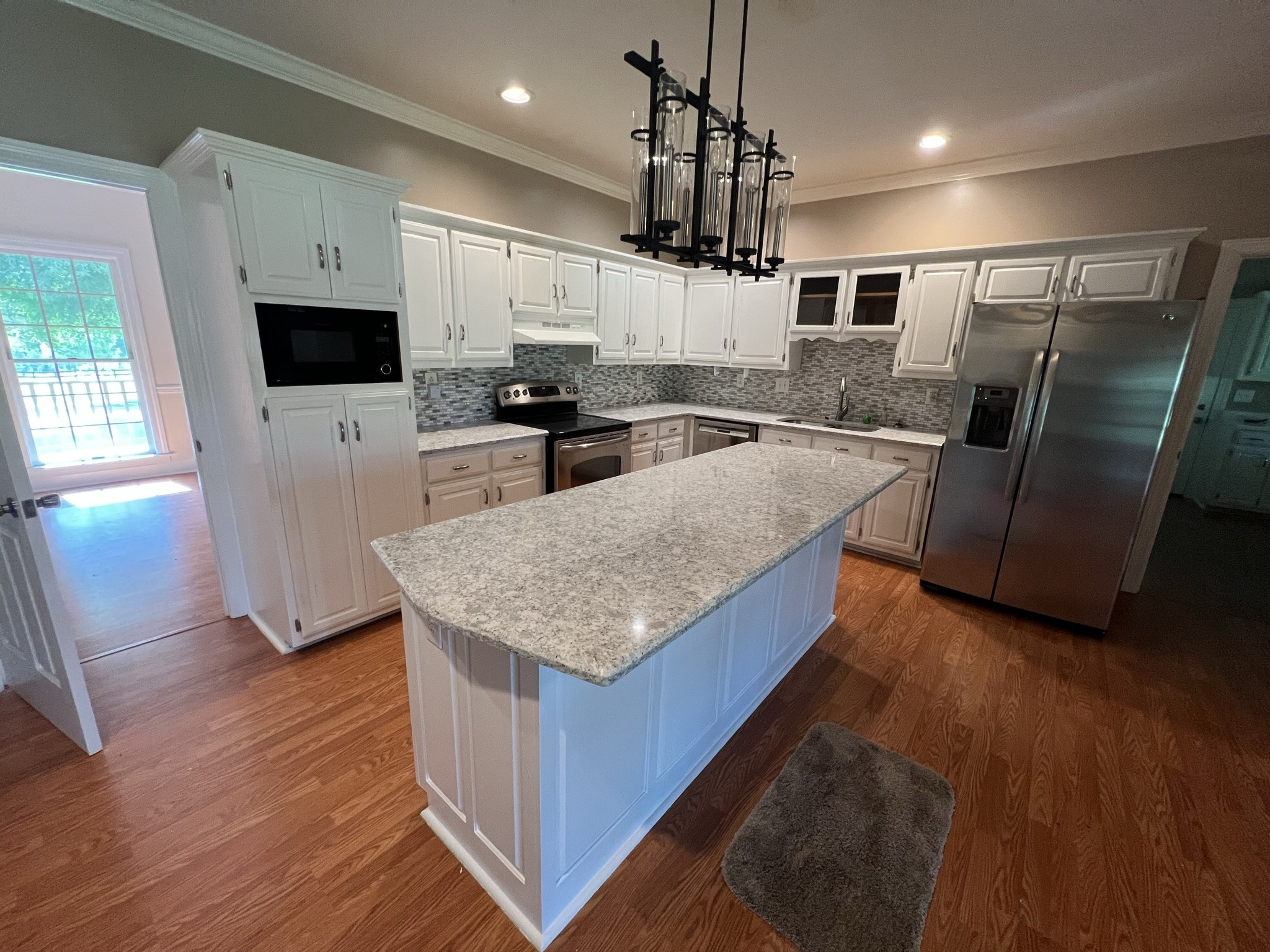 584 Corinth Road Portland, TN 37148 - Photo 40 of 42 a kitchen with stainless steel appliances granite countertop a refrigerator a stove a sink a microwave and wooden floor