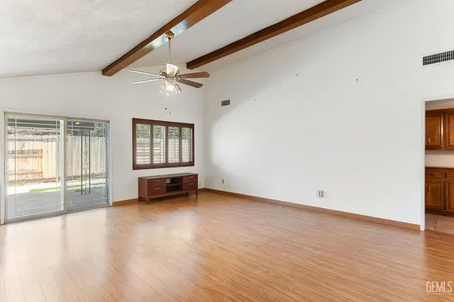 a living room with stainless steel appliances kitchen island granite countertop wooden floors and a view of living room