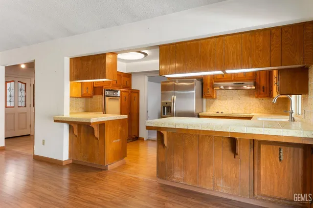 a kitchen with kitchen island granite countertop wooden cabinets and a sink