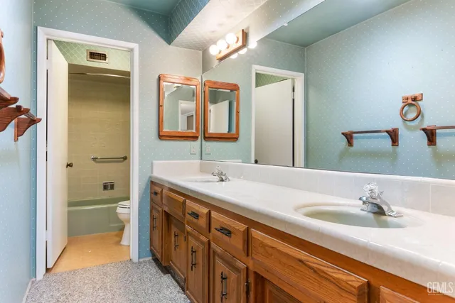 an empty room with chandelier fan and windows