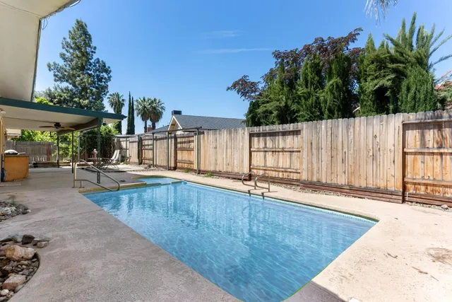 a view of a house with backyard and sitting area