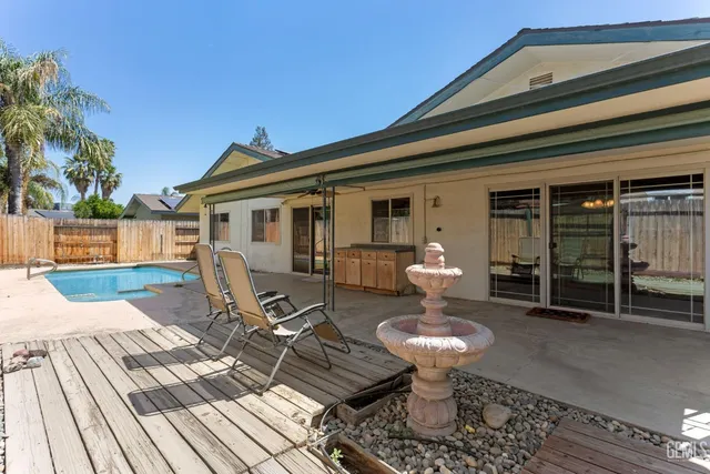 a view of a patio with table and chairs with wooden floor and fence