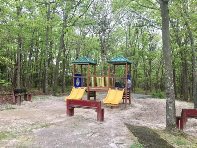 227 Hill Rise Calverton, NY 11933 - Photo 18 of 21 a bench is sitting in the middle of a park