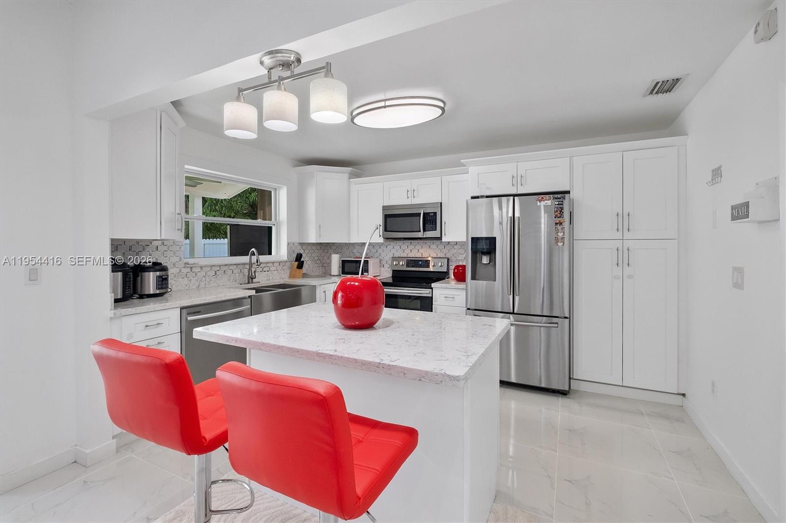 26161 Southwest 130th Avenue Homestead, FL 33032 - Photo 2 of 51 a kitchen with stainless steel appliances granite countertop a refrigerator a stove top oven a sink dishwasher and white cabinets