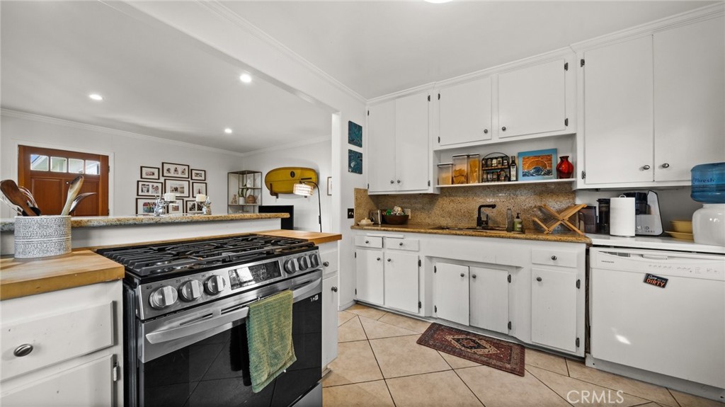 1406 17th Street Manhattan Beach, CA 90266 - Photo 11 of 60 a kitchen with stainless steel appliances granite countertop a stove and white cabinets