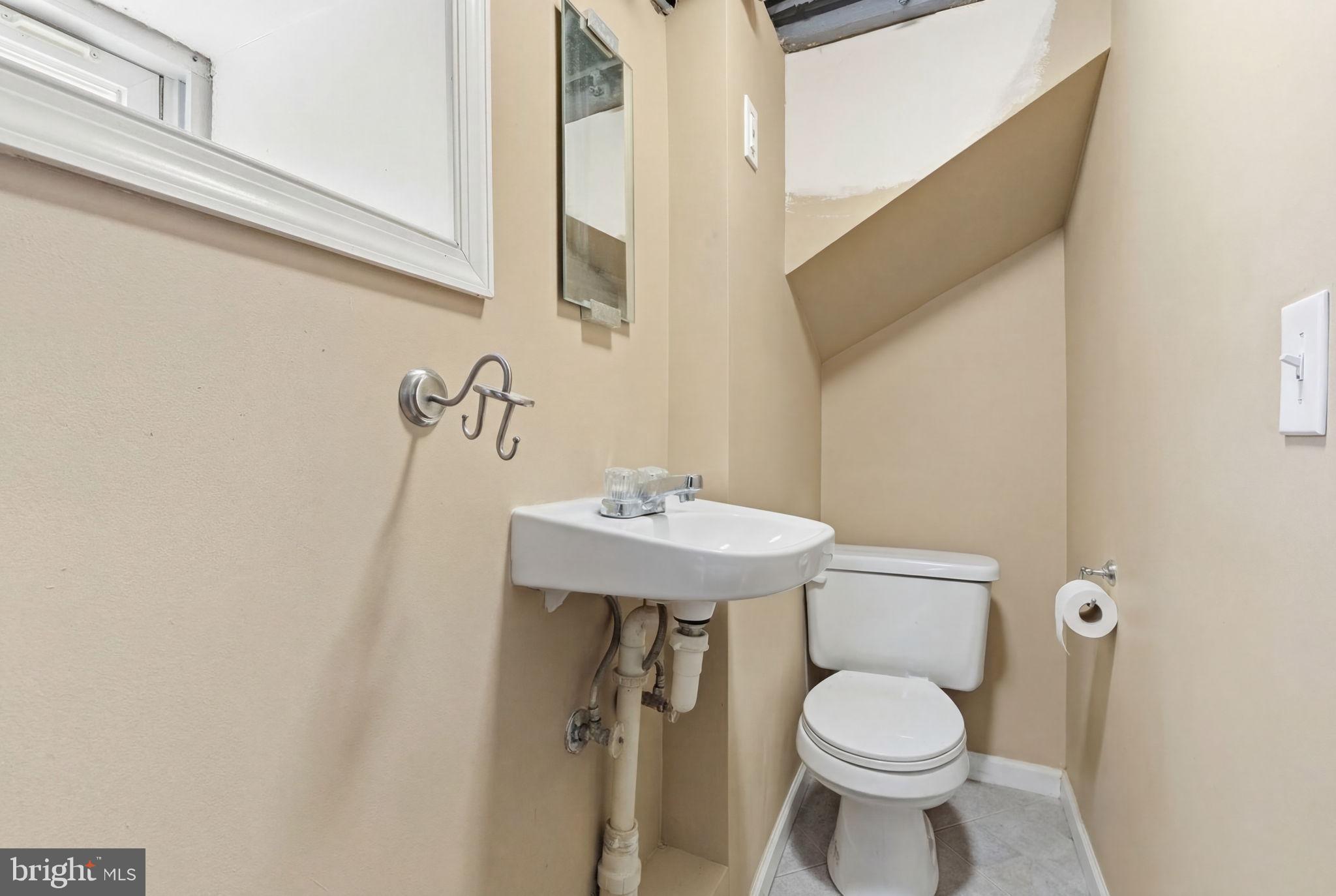 405 Leverington Avenue Philadelphia, PA 19128 - Photo 23 of 25 a bathroom with a sink a toilet and mirror