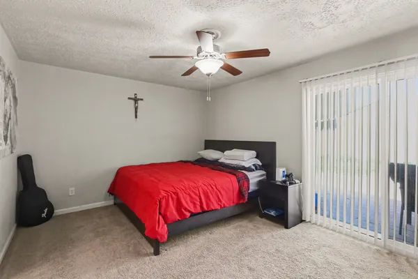 a bed room with a bed and a ceiling fan