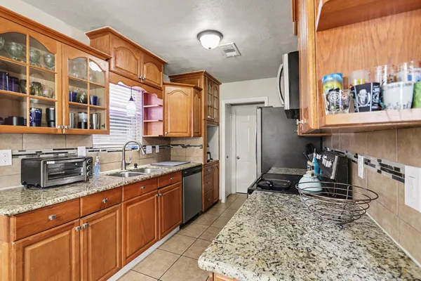 a kitchen with stainless steel appliances granite countertop a sink stove and cabinets