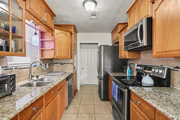 a kitchen with stainless steel appliances granite countertop a sink stove and refrigerator