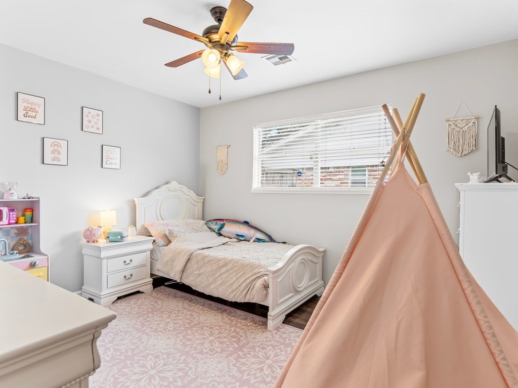 4009 Rice Avenue Bay City, TX 77414 - Photo 14 of 26 a bedroom with a bed and a chandelier