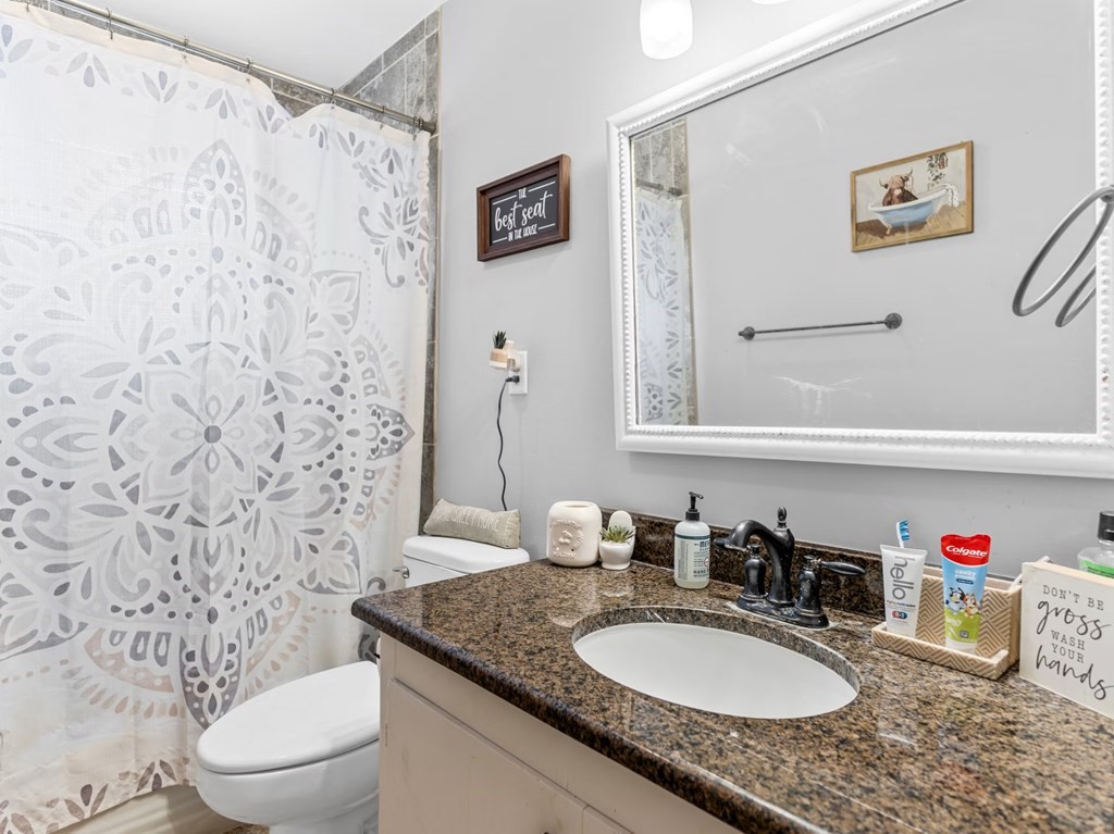 4009 Rice Avenue Bay City, TX 77414 - Photo 17 of 26 a bathroom with a granite countertop sink and a mirror