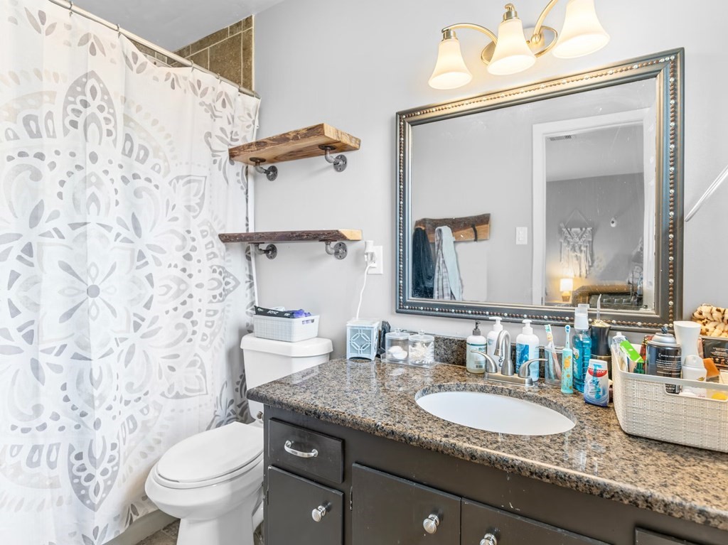 4009 Rice Avenue Bay City, TX 77414 - Photo 8 of 26 a bathroom with a granite countertop sink mirror vanity and toilet