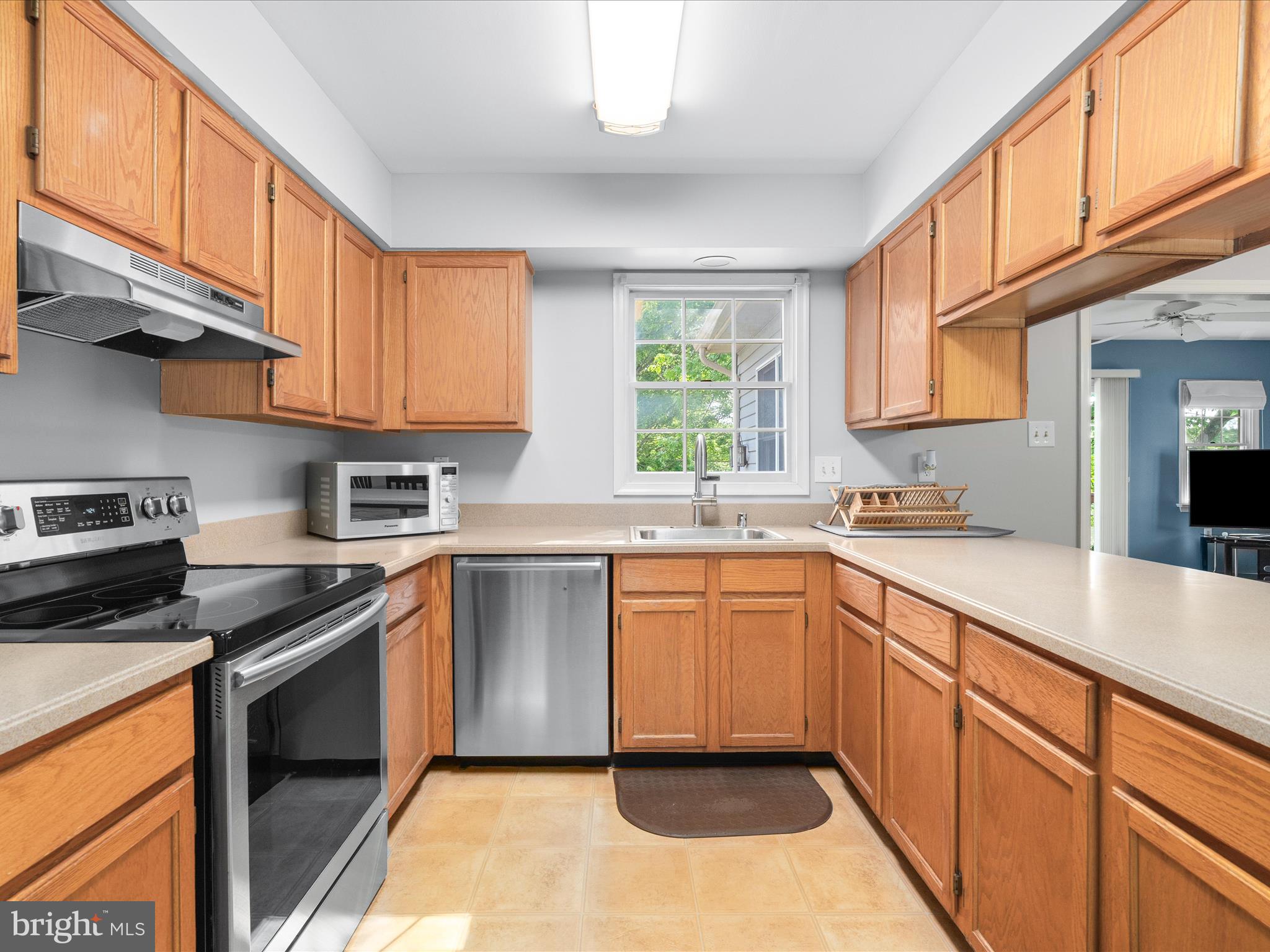 4609 Feldspar Road Middletown, MD 21769 - Photo 17 of 63 a kitchen with stainless steel appliances granite countertop a stove a sink and a microwave