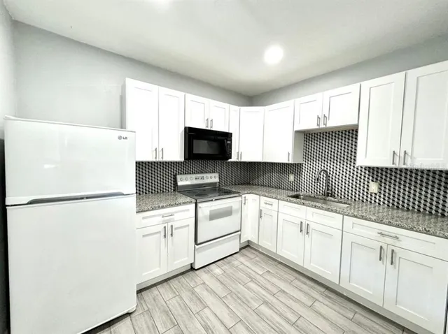 a kitchen with white cabinets and white appliances