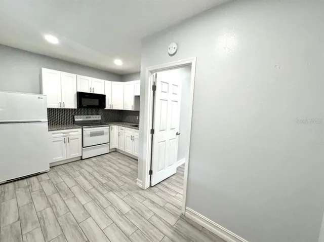 a kitchen with white cabinets and white appliances