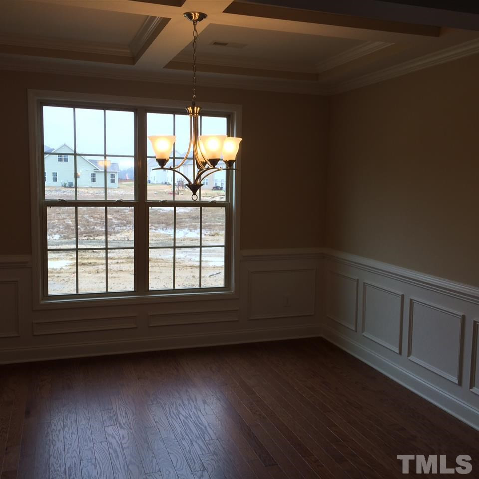 coffered ceiling with crown molding along with wainscotting & chair rail with all its hardwoods. Dining Room
