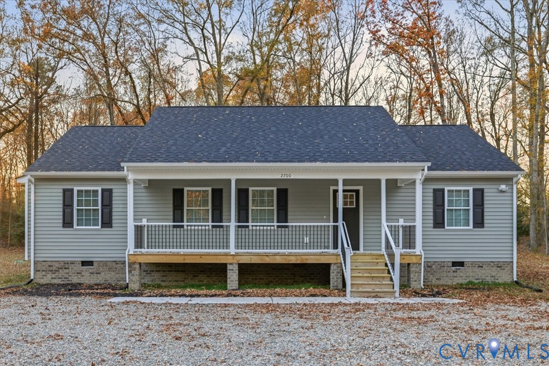 a view of a house with a yard and large tree