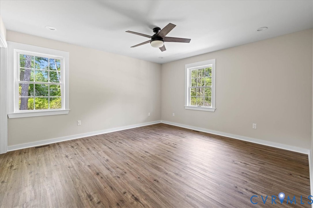 2700 River Road Prince George, VA 23875 - Photo 15 of 24 an empty room with wooden floor windows and ceiling fan