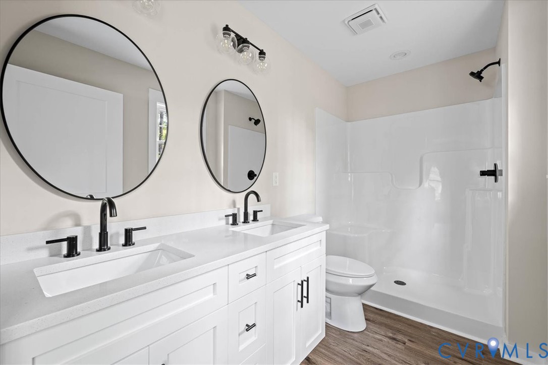 2700 River Road Prince George, VA 23875 - Photo 17 of 24 a bathroom with a double vanity sink toilet and a mirror