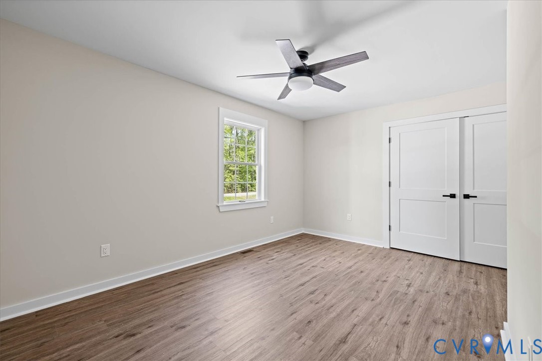 2700 River Road Prince George, VA 23875 - Photo 18 of 24 an empty room with wooden floor fan and windows