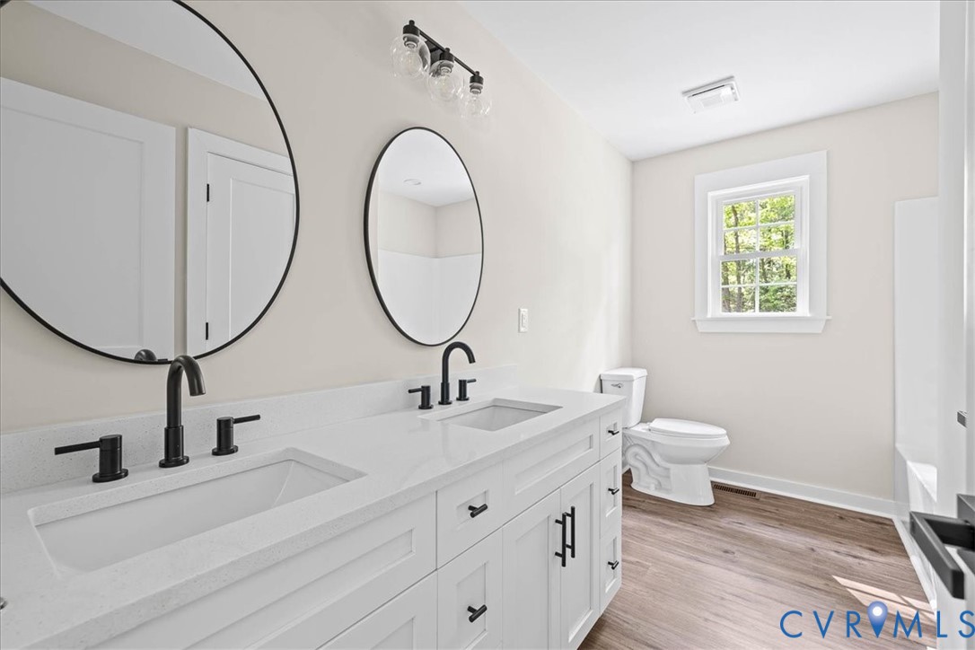 2700 River Road Prince George, VA 23875 - Photo 21 of 24 a bathroom with a toilet a sink and a mirror