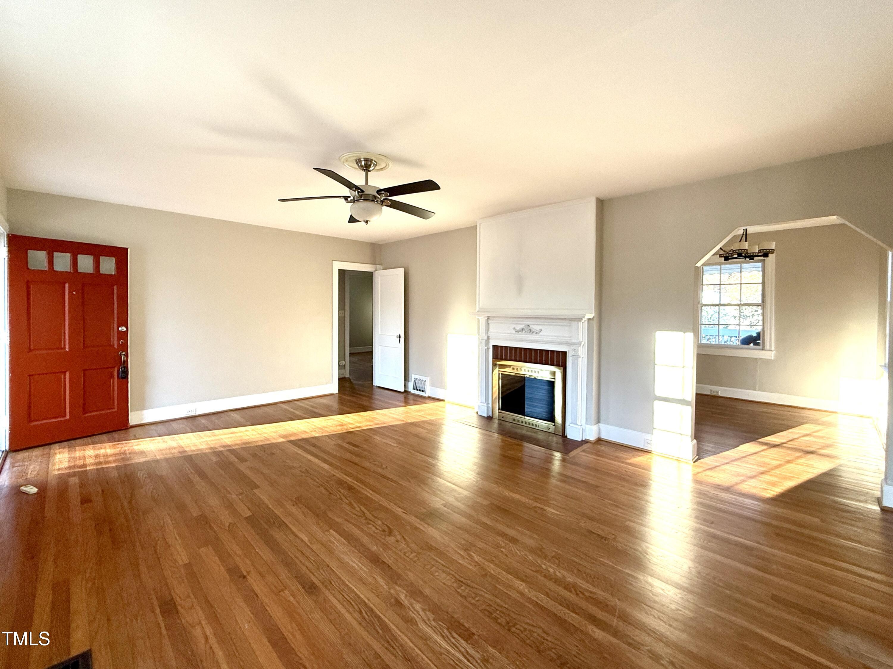2409 Shenandoah Avenue Durham, NC 27704 - Photo 4 of 31 a view of empty room with wooden floor and fireplace