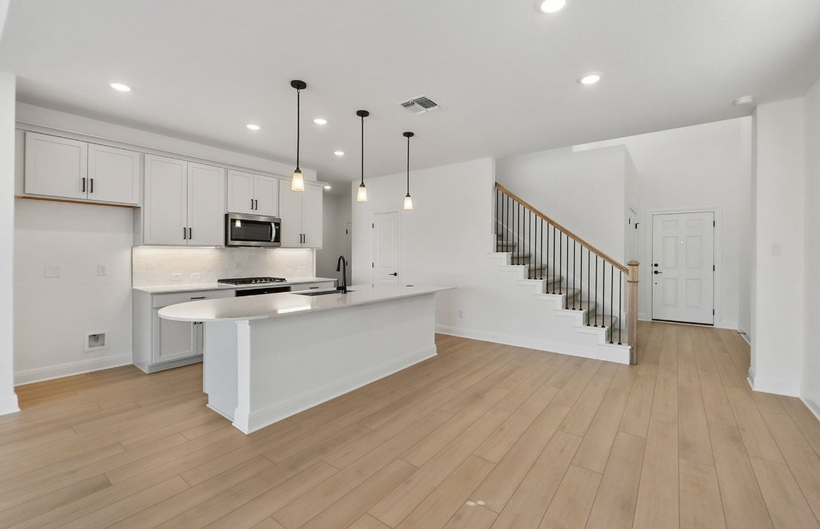 217 Regatta Trail Leander, TX 78641 - Photo 9 of 28 a view of kitchen with wooden floor and electronic appliances