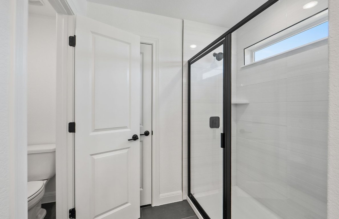 217 Regatta Trail Leander, TX 78641 - Photo 19 of 28 a bathroom with a glass shower door