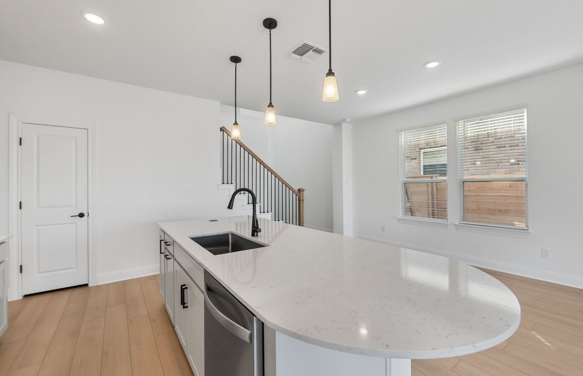 217 Regatta Trail Leander, TX 78641 - Photo 7 of 28 a kitchen with stainless steel appliances granite countertop a sink a refrigerator and a stove