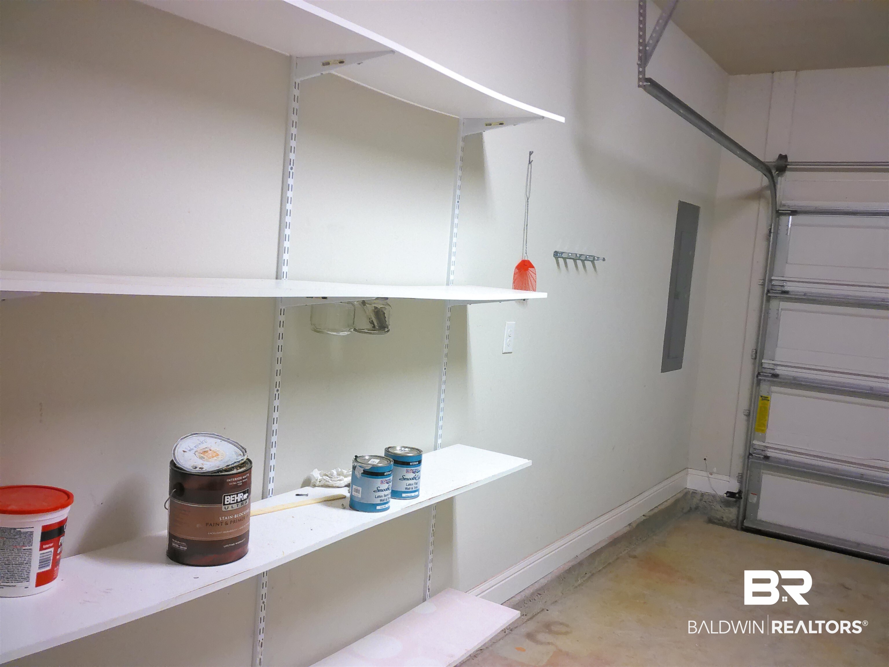 25806 Pollard Road, Unit 23 Daphne, AL 36526 - Photo 15 of 16 Garage featuring baseboards and electric panel