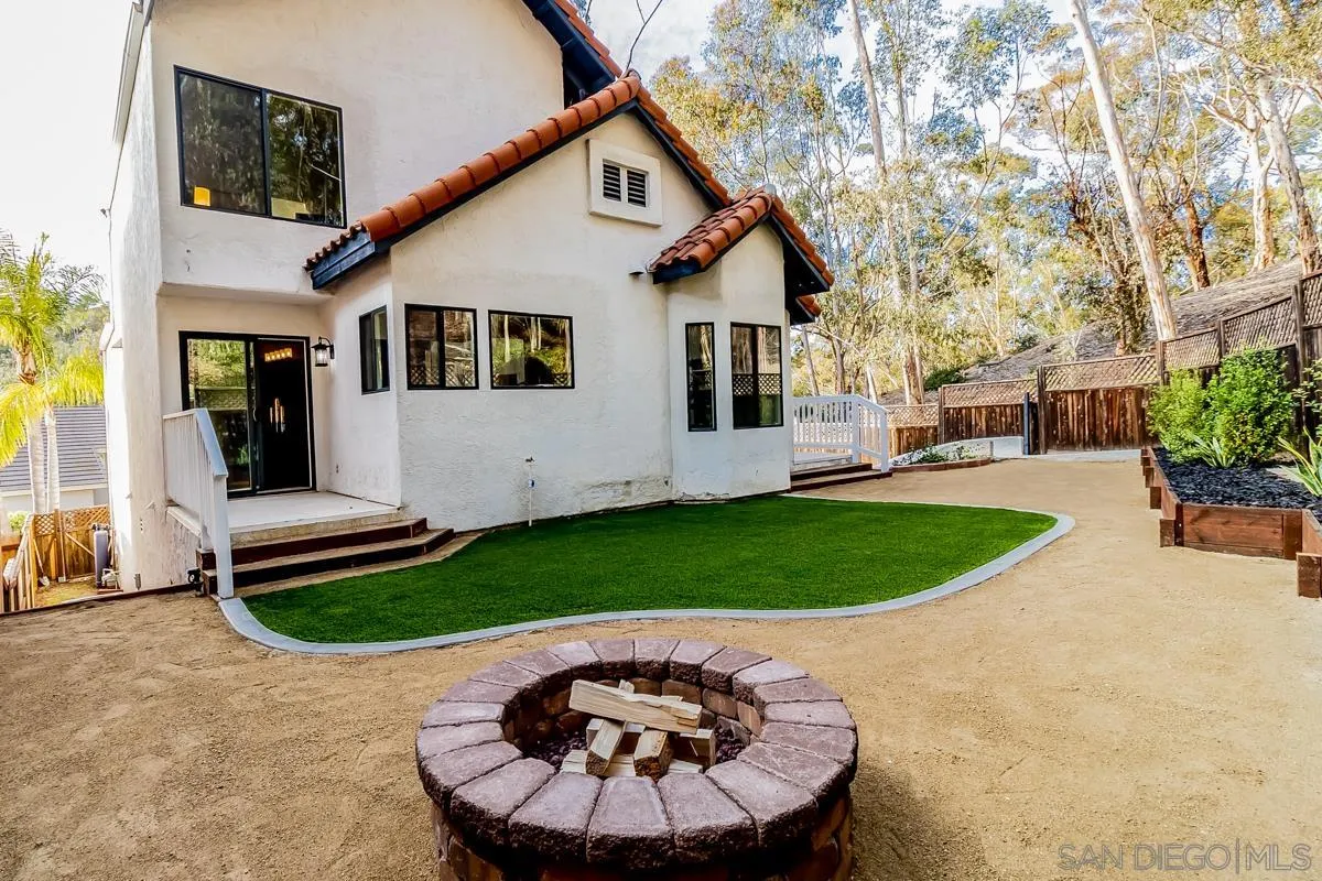 2710 Fernglen Road Carlsbad, CA 92008 - Photo 25 of 37 a view of a white house with a swimming pool and a yard with potted plants