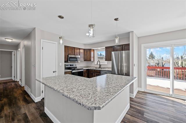 6319 Chippewa Road Colorado Springs, CO 80915 - Photo 21 of 36 Kitchen featuring appliances with stainless steel finishes, hanging light fixtures, a kitchen island, and plenty of natural light