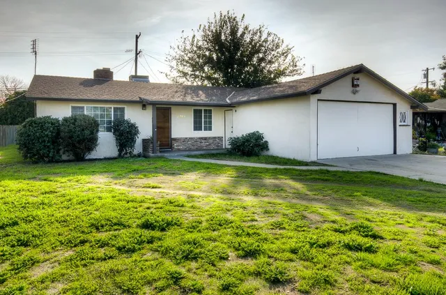 a front view of house with yard and garage