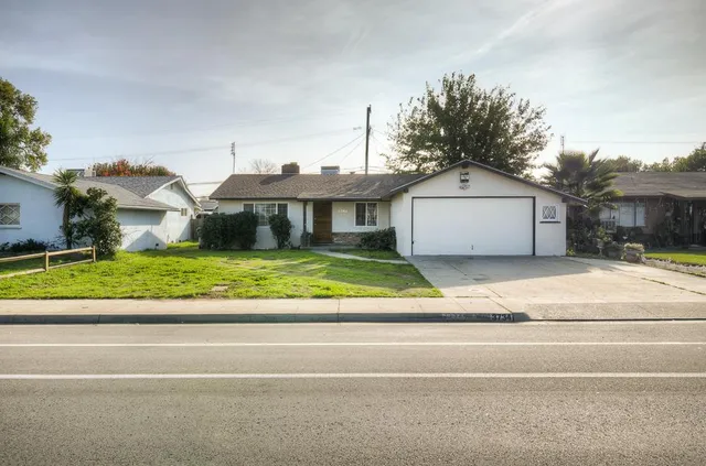 a front view of a house with a garden and plants
