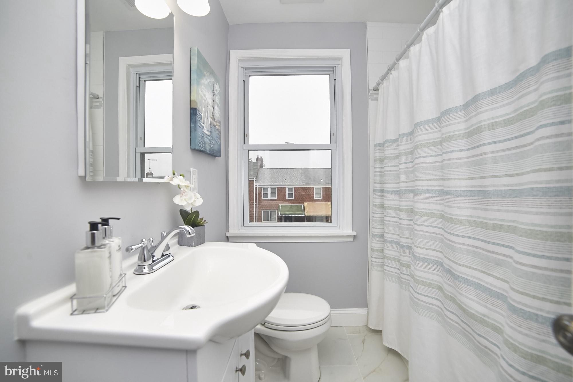 3814 Elkader Road Baltimore, MD 21218 - Photo 15 of 30 a bathroom with a sink a toilet and mirror