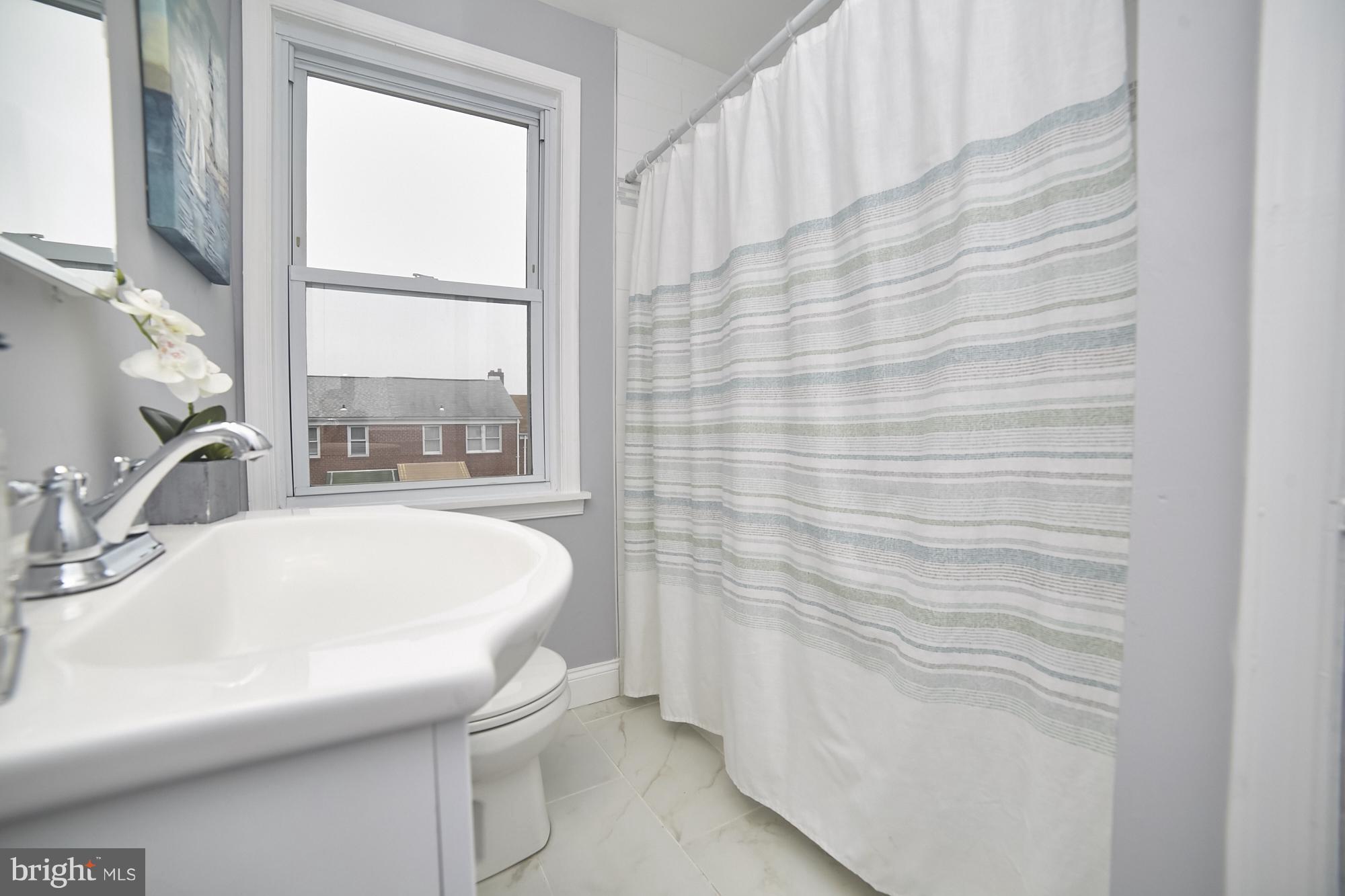 3814 Elkader Road Baltimore, MD 21218 - Photo 16 of 30 a bathroom with a sink a vanity and a bathtub