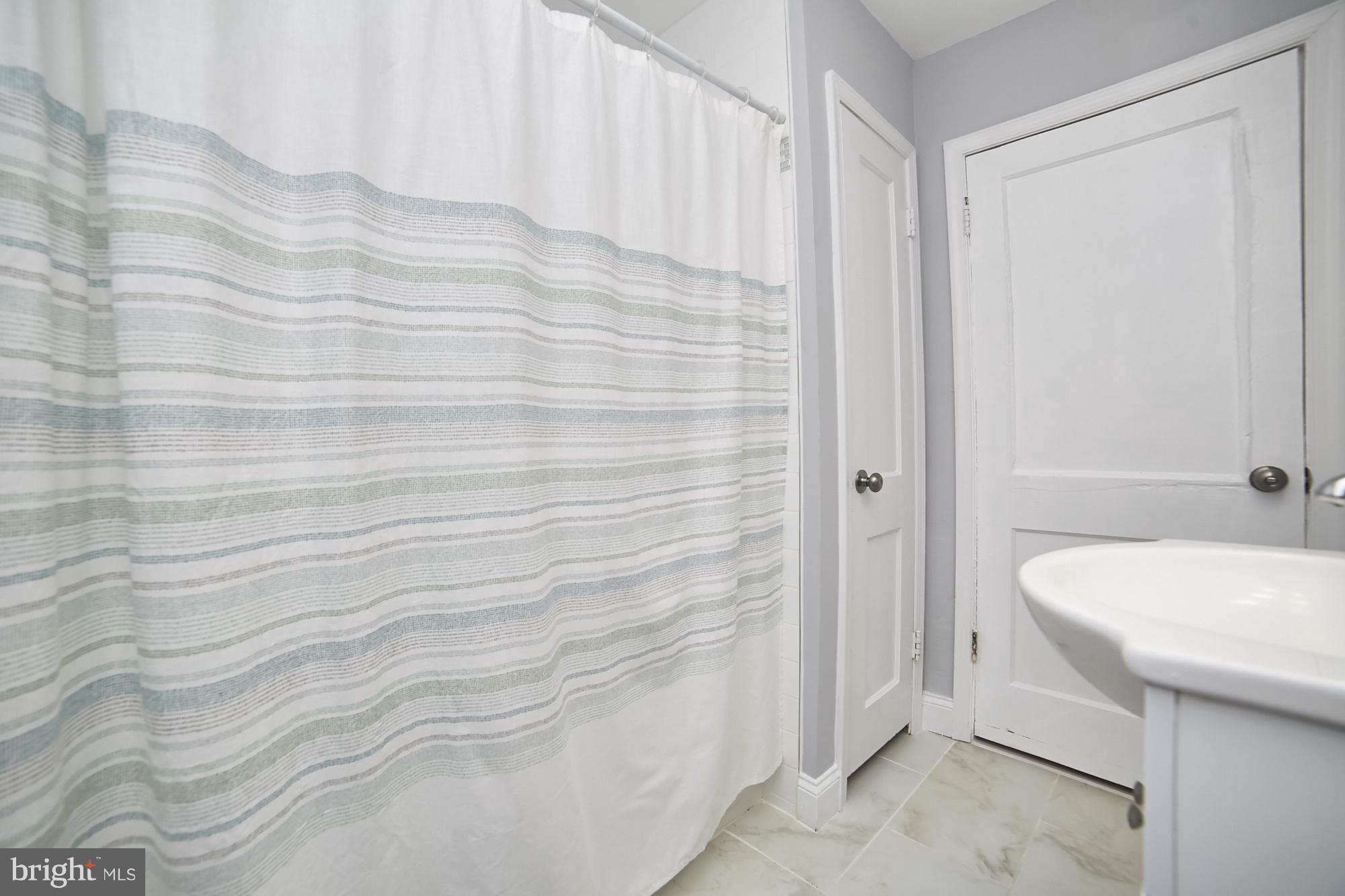 3814 Elkader Road Baltimore, MD 21218 - Photo 17 of 30 a bathroom with a sink a toilet and shower