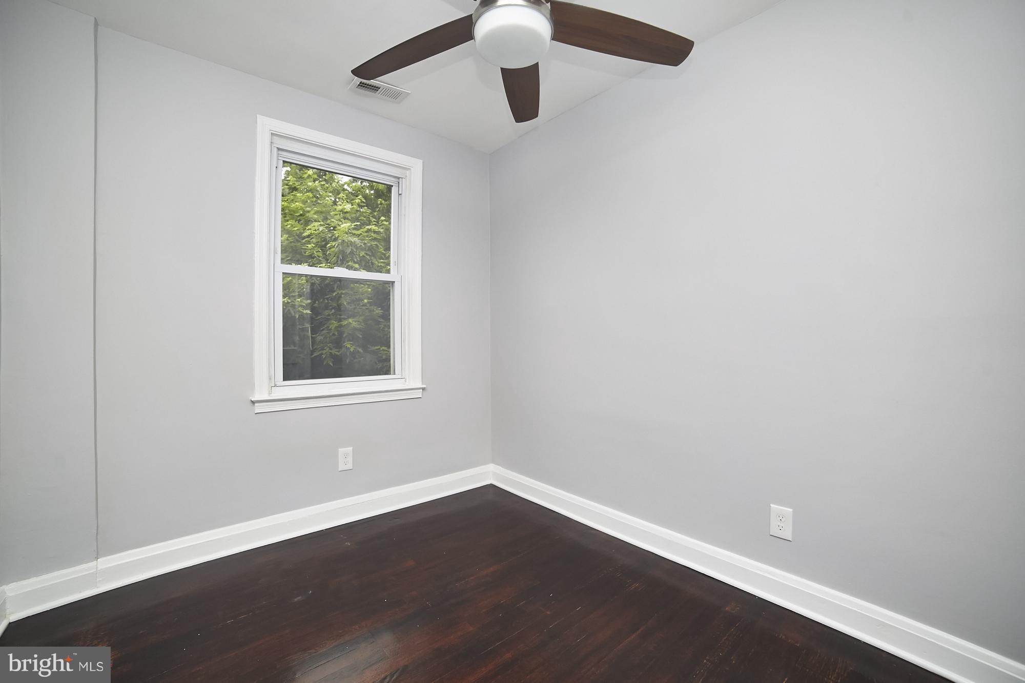 3814 Elkader Road Baltimore, MD 21218 - Photo 23 of 30 an empty room with wooden floor and windows