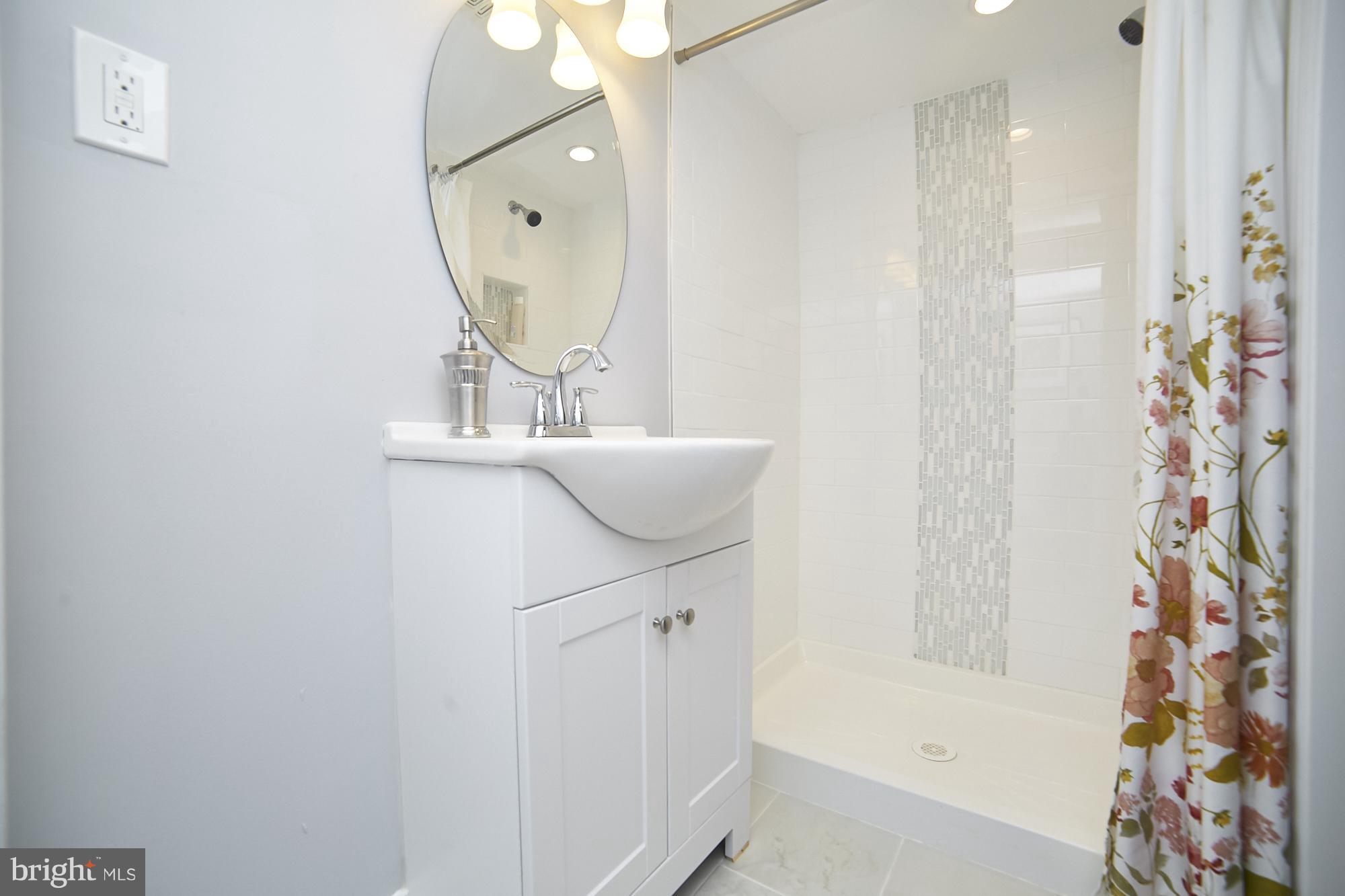 3814 Elkader Road Baltimore, MD 21218 - Photo 28 of 30 a bathroom with a sink a mirror and a shower